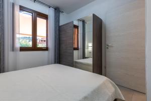 モンテ・ナイにあるVilletta Playa Biloのベッドルーム(白いベッド1台、窓付)
