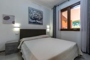 モンテ・ナイにあるVilletta Playa Biloのベッドルーム(白いベッド1台、窓付)