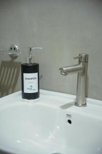 a soap bottle sitting on top of a bathroom sink at Wilpattu Green Cabin in Achchamulai +204 photos