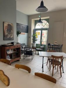 ein Esszimmer mit Tischen und Stühlen in einem Zimmer in der Unterkunft Hôtel De L'Horloge in Auvillar