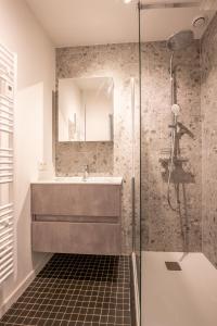 La salle de bains est pourvue d'un lavabo et d'une douche. dans l'établissement SeaView with style, à Ostende