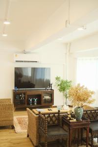 Una sala de estar con una mesa y un televisor. en Private Full-Floor Spacious 5BR in China Town, en Bangkok