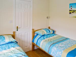 ムンデスリーにあるWatchkeepers Cottageのベッドルーム1室(ベッド2台付)が備わるアパートメントです。