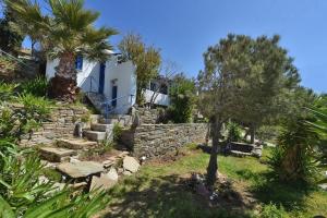 una casa con un muro di pietra e palme di La Casa Di Maryolo Zannel seaside serenity a Kardhianí