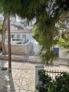 a stone walkway with trees and a white building at Piteoussa Plus Hydra in Hydra