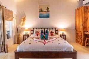 a bedroom with a bed with shoes on it at Bale Sampan Boutique Bungalows in Gili Trawangan