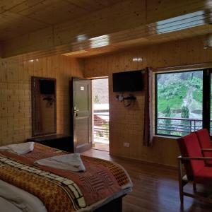 a bedroom with a bed and a window and a television at Ashuna Hotel & Resort in Kargil