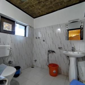 a bathroom with a sink and a toilet at Ashuna Hotel & Resort in Kargil