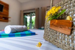 a bed with a basket of flowers on it at Bale Sampan Boutique Bungalows in Gili Trawangan