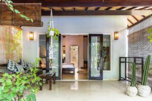 an open living room with glass doors and plants at Bale Sampan Boutique Bungalows in Gili Trawangan +37 photos