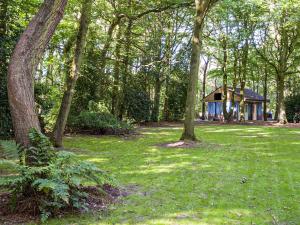 a house in the middle of a field with trees at Goosewing Hut-qu7072 in Melton Constable