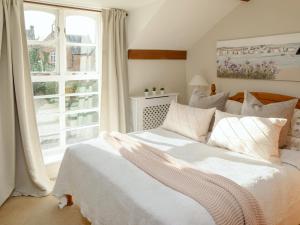 a bedroom with a white bed and a window at The Old Stable - Dey in Marshwood