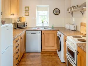 a kitchen with a sink and a dishwasher at The Old Stable - Dey in Marshwood