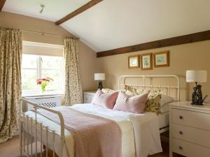 a bedroom with a white bed and a window at The Hayloft- Dws in Marshwood