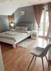 een slaapkamer met een bed en een stoel erin bij Cozy House in Lazarevac