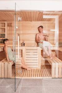 deux hommes sont assis dans un sauna dans l'établissement Exzelent Residence, à Anterselva di Mezzo
