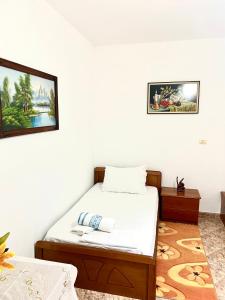 een slaapkamer met een bed en een foto aan de muur bij Hajdini Apartament in Sarandë
