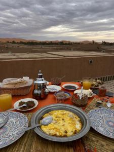 a table with a plate of food on top at Camels House in Merzouga