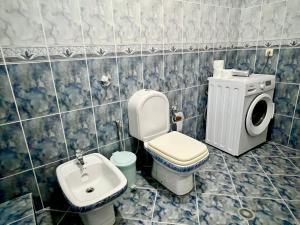 een badkamer met een wastafel en een wasmachine bij Hajdini Apartament in Sarandë