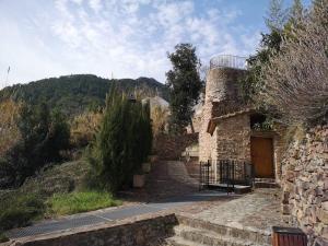 un antiguo edificio de piedra con una puerta y una montaña en Casa Rural Ana Maria Ain en Ahín
