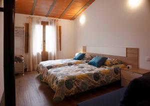 Ahín的住宿－Casa Rural Ana Maria Ain，一间卧室设有两张床和窗户。