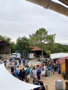 une foule nombreuse de personnes debout autour d'une tente dans l'établissement Camping de la ferme aux ânesses, mobil home myrtille, à Bressuire