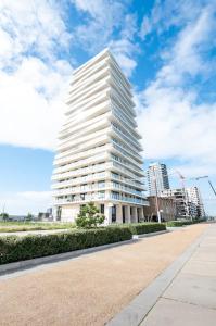 un grand bâtiment blanc dans une ville avec des bâtiments dans l'établissement Prachtig appartement met zwembad en fitness, à Ostende