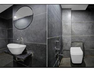 a bathroom with a sink and a toilet and a mirror at Hotel Saarthi Inn, Surat in Surat