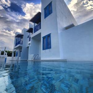 um edifício branco com água à sua frente em Ipoh Santorini Hideaway - Hotel Inspired em Ipoh