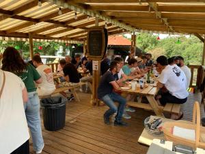 a group of people sitting at tables on a deck at Camping de la ferme aux ânesses, Mobil Home Câline in Bressuire