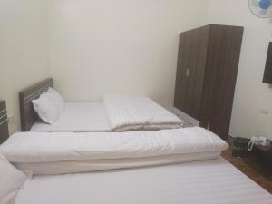 um quarto com 2 camas e um armário de madeira em Homstay A Hến 