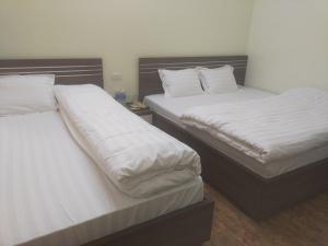 duas camas sentadas uma ao lado da outra num quarto em Homstay A Hến 