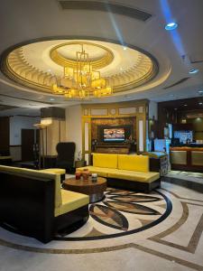 a hotel lobby with a yellow couch and a chandelier at Kay Hotel and Residences in Angeles