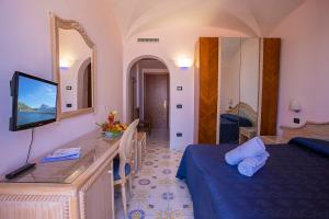 una camera d'albergo con letto e specchio di Hotel Terme Cristallo Palace & Beach a Ischia