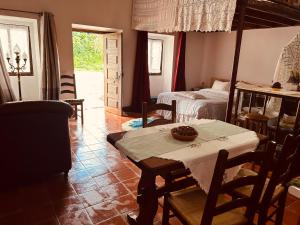 a living room with a table and a bed at Mãe Home Carril in Caldas da Rainha