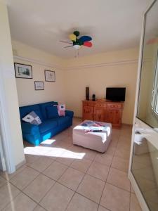 sala de estar con sofá azul y TV en appartamento in pineta vista mare, en Santa Caterina di Nardò