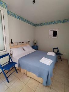 1 dormitorio con 2 camas y silla azul en appartamento in pineta vista mare, en Santa Caterina di Nardò