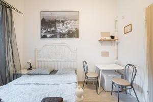 een slaapkamer met een bed en een tafel en stoelen bij Laykonik in Krakau