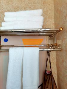 a towel rack in a bathroom with white towels at Dali Favorite Inn in Dali