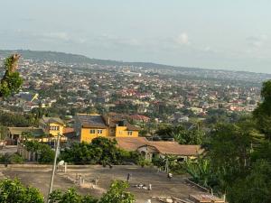 een uitzicht op een stad met een geel huis bij Calm Hillside Swimming Pool Villa Apartment in Accra