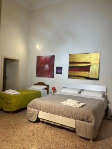 a bedroom with two beds and a painting on the wall at Salento b&b Trepuzzi in Trepuzzi