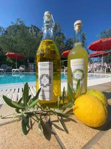 due bottiglie di limonata e limone accanto a una piscina di Residence Miravalle a Limone sul Garda