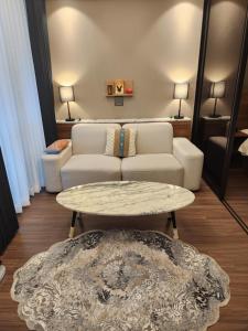 Sienna Ambassador Residence في بوسان: غرفة معيشة مع أريكة وطاولة قهوة