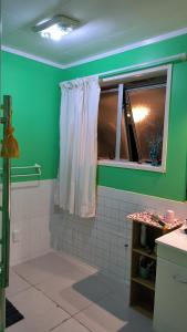 a green bathroom with a shower with a window at Wendy's Holiday Home in Auckland