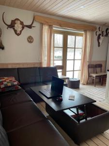 uma sala de estar com um sofá e um computador portátil sobre uma mesa em Ööbiku Holiday House em Antsla