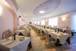 un comedor con mesas y sillas con manteles blancos en Hotel Terme Cristallo Palace & Beach en Ischia