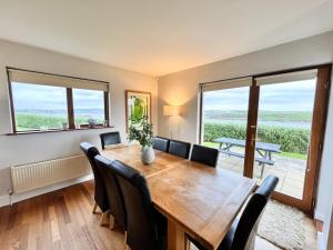 a dining room with a wooden table and chairs at Sea Haven · Tranquil Costal Retreat in Youghal