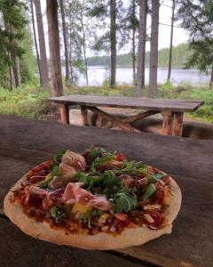 uma pizza sentada em cima de uma mesa de madeira em Kylås Vildmark em Skillingaryd