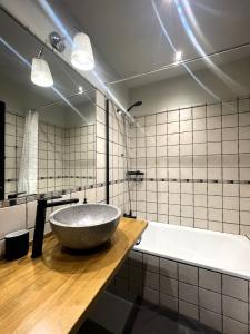 a bathroom with a large stone sink and a tub at Apartamento dúplex en el puente histórico, Gra de Fajol in Camprodon