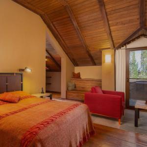 Kzylkʼend的住宿－圖芬基安阿凡馬拉克茨阿帕塔酒店，一间卧室配有一张大床和一张红色椅子